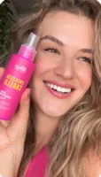 Mulher sorrindo com o spray Engrossa Cabelo