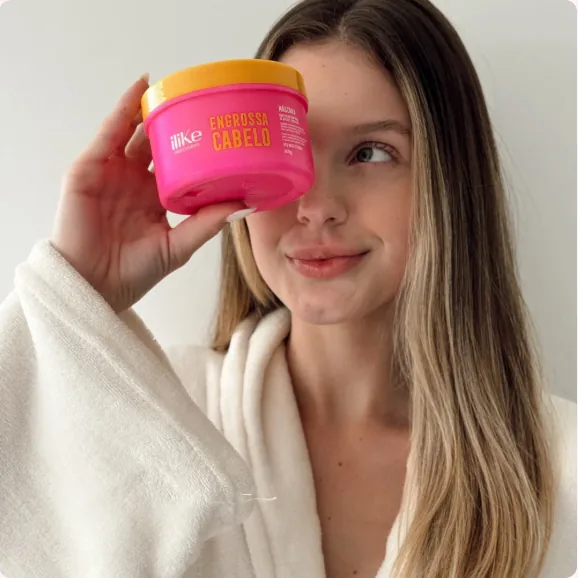 Mulher segurando a máscara Engrossa Cabelo iLike
